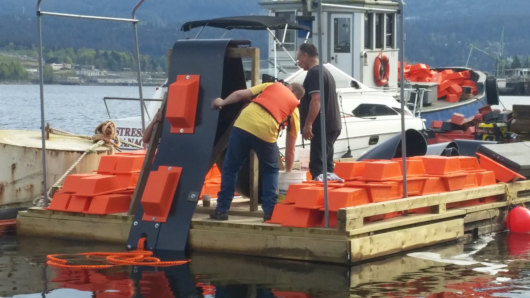 Technicians assembling boom float sections on work float