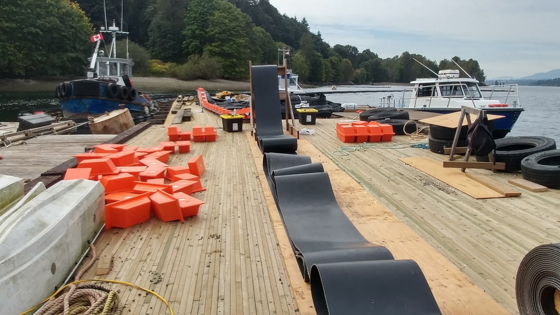 Construction containment boom assembly on work dock