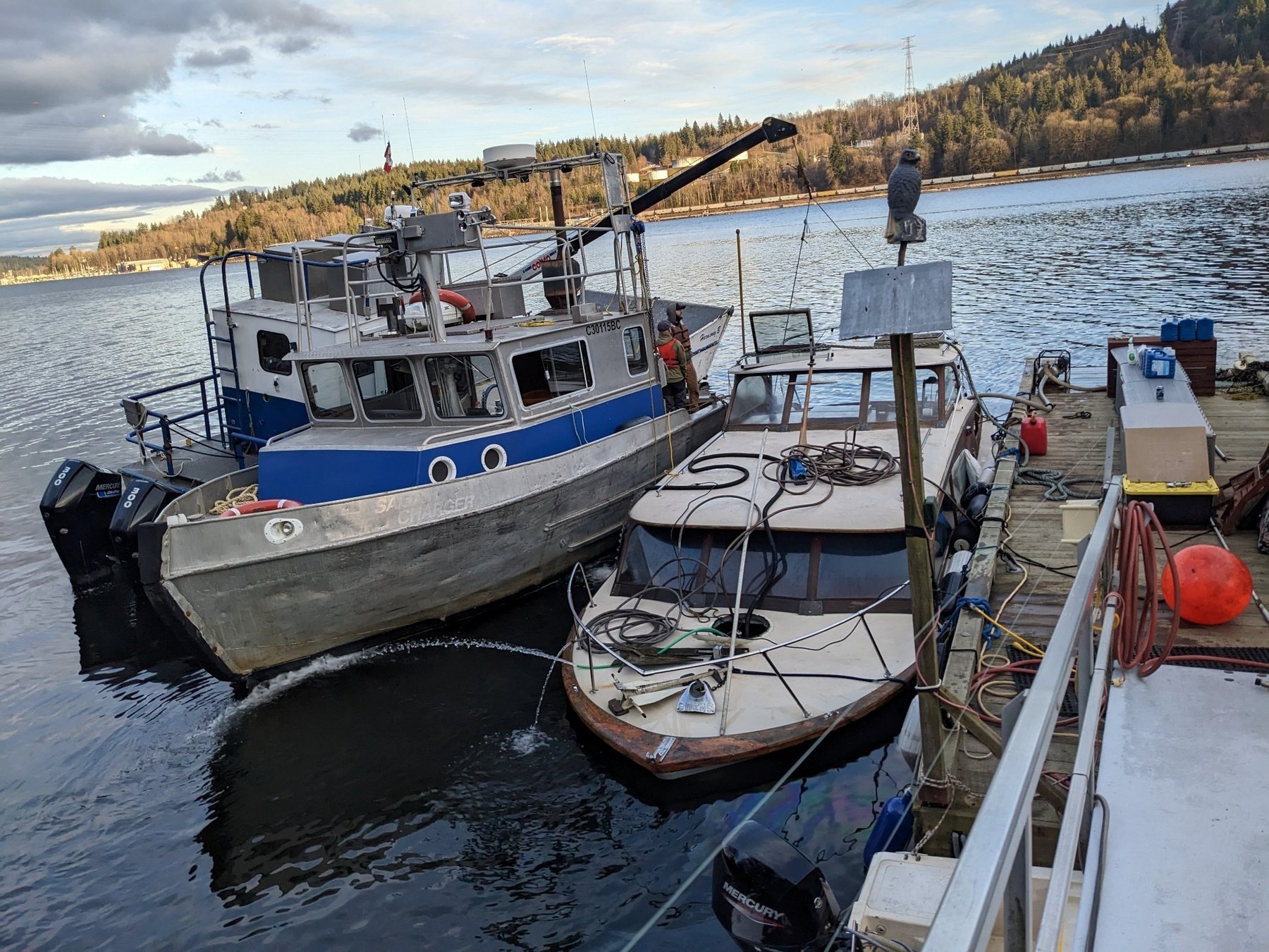 Derelict vessel being dewatered alongside Seaforth work boat during salvage operation